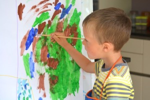 Young boy painting at an easel