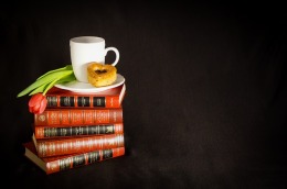 Stack of books with coffee and pastry on top