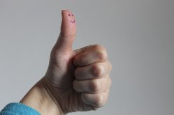 Thumb up with a smiley face on the thumb