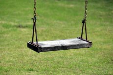 wooden swing on a background of green grass