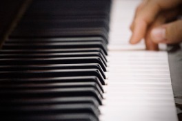 Piano keyboard with fingers on a key